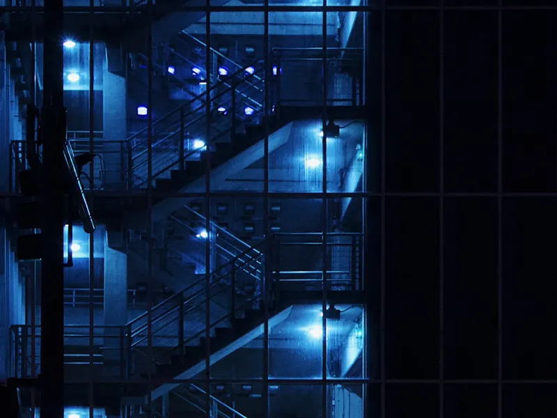 Photo of an industrial staircase bathed in blue light.
